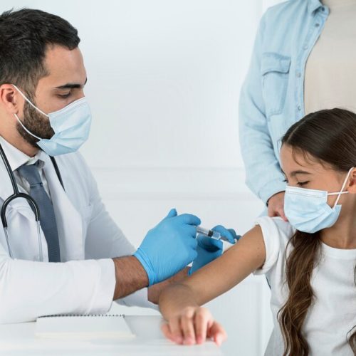 male-doctor-vaccinating-little-girl-that-s-supported-by-her-mother_23-2148755611