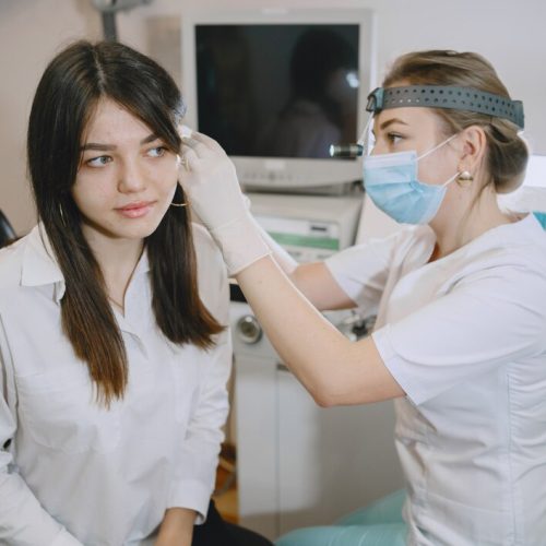 woman-patient-medical-office-doctor-medical-mask-lor-checks-woman-ears_1157-45539