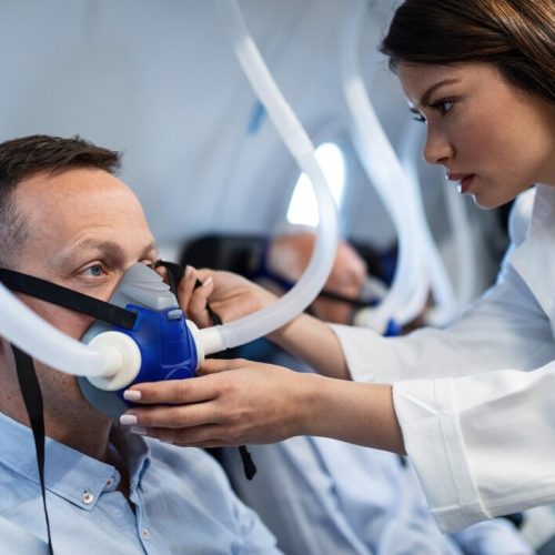 young-doctor-assisting-patient-with-mask-hyperbaric-oxygen-therapy-clinic_637285-702